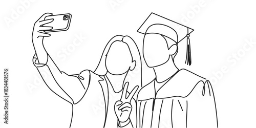 Two graduates in caps and gowns take a joyful selfie to celebrate their academic achievement.