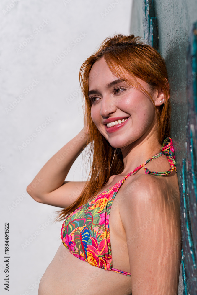Naklejka premium Close-up of woman leaning against wall in floral bikini top