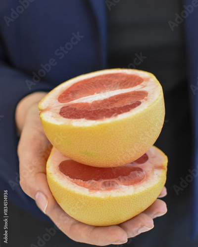 Fresh grapefruit halves in hands