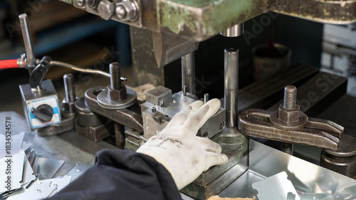 Metal stamping machine operator working with precision die