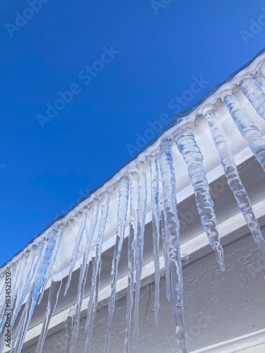icicles on eavestrough and blue sky