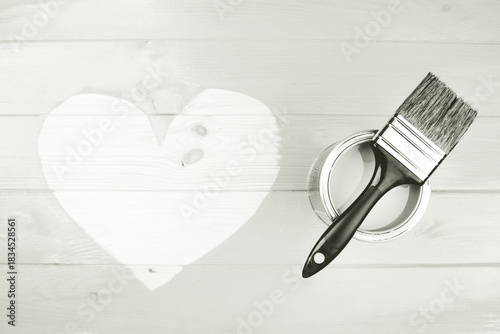 Paint can and brush resting on wooden planks with a hand painted heart shape. Concepts of love, diy, and home improvement. Color of 2026 year dancer in the white cloud
