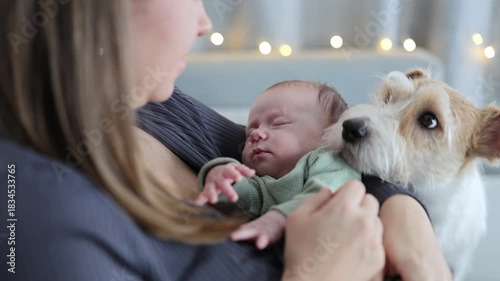 A woman is caring for her baby. The mother is rocking the baby in her arms. The newborn is sleeping. A close-up of the baby in the woman's arms.