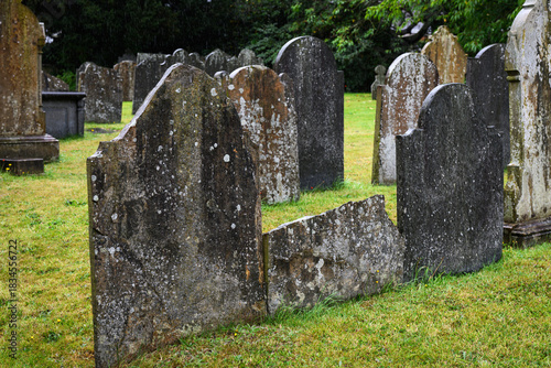 Ancient headstones in rows in cemetary in wet weather