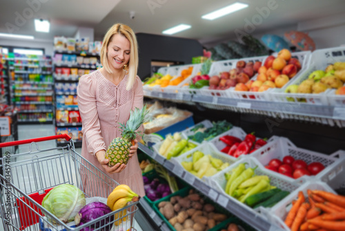 Woman shopping for fresh fruit and vegetables in grocery store