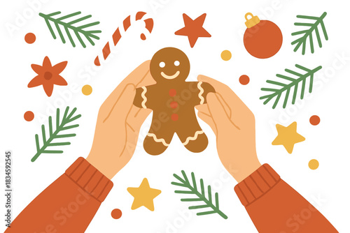 A top-down view of pretty female hands holding a gingerbread man on a table decorated with Christmas ornaments