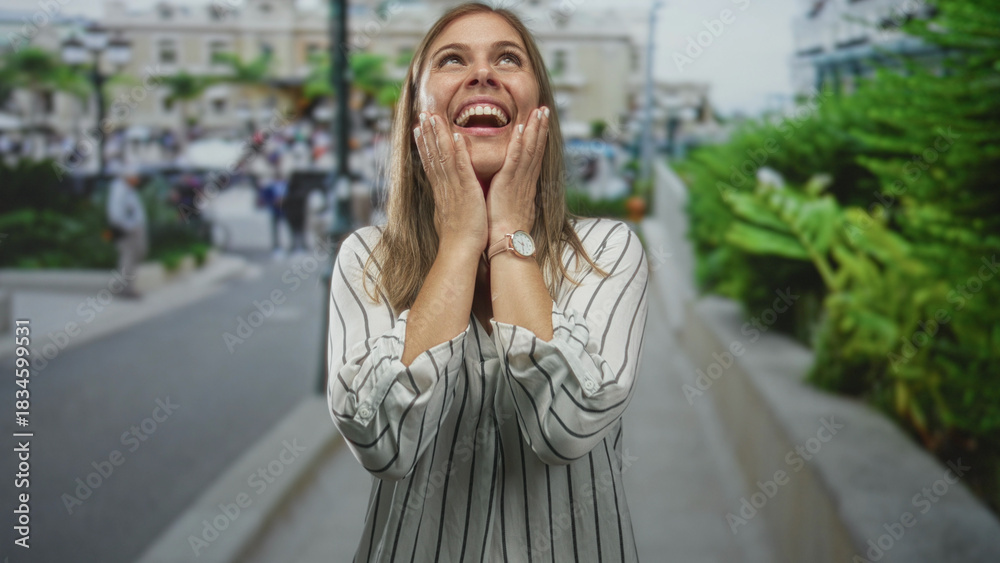Fototapeta premium Woman raising open palms and shrugging shoulders on crowded daytime street; joy confidence optimism.