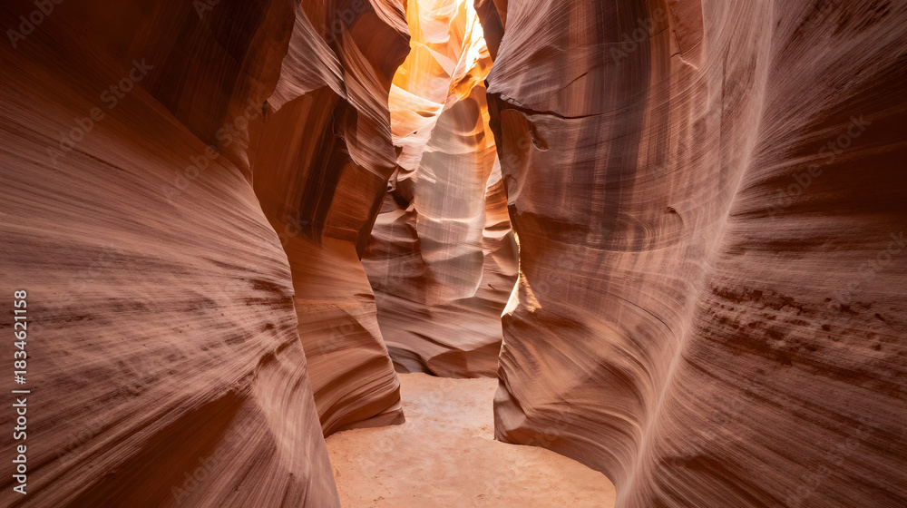 Naklejka premium Narrow canyon with sunlight creating soft golden beams through sandstone walls