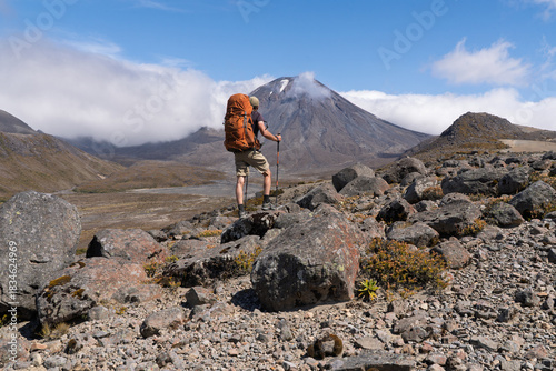 Hiker admiring Mount Ngauruhoe volcano on Tongariro Northern Circuit, NZ