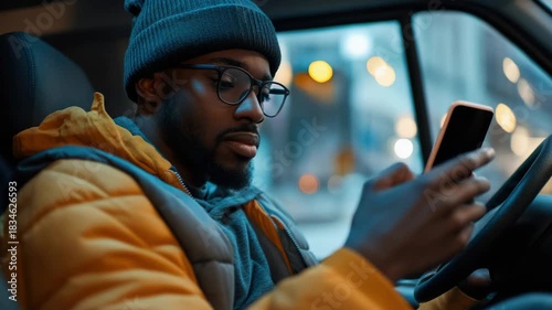 Man in car looking at cell phone.