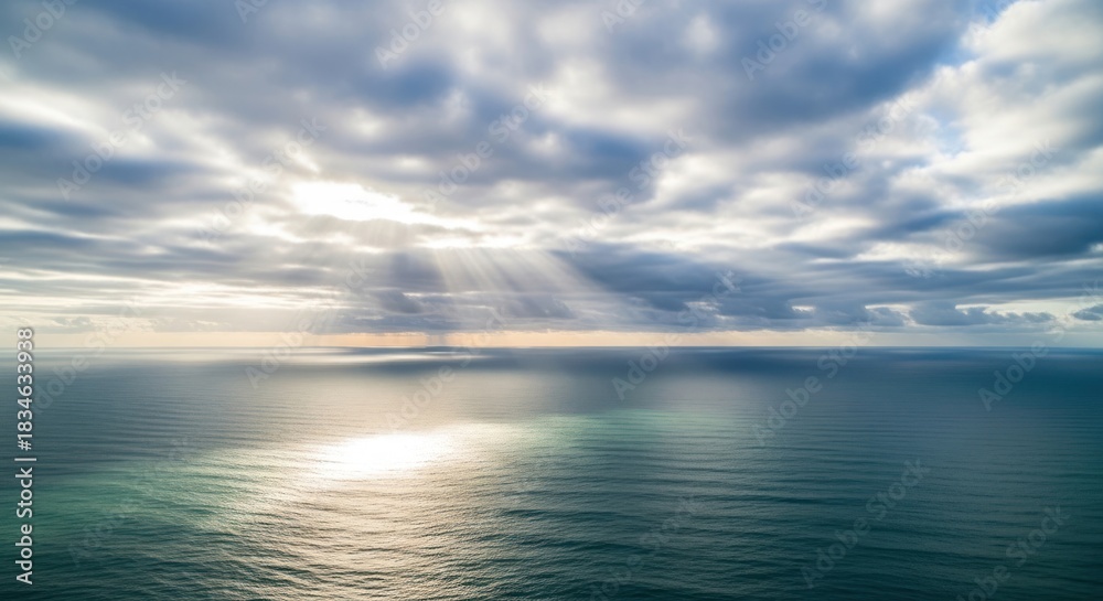 Fototapeta premium Sun rays break through the clouds over the ocean.