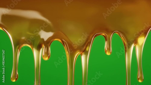 Sweet golden syrup or honey pouring and dripping in a thick stream, isolated on a vibrant green screen for easy compositing