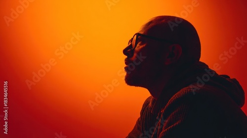 Mans silhouette glasses orange background