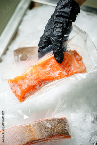 Frozen salmon fillet placed on ice, showing fresh texture and bright orange color.