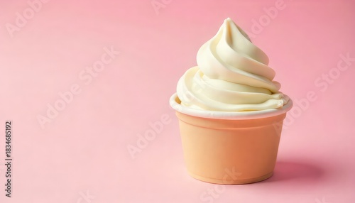 A cup of vanilla soft serve ice cream with a swirl on a pink background in a studio setting shot well