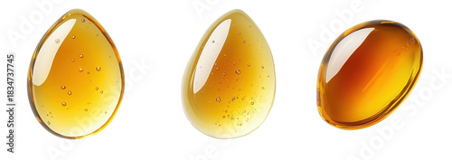 Three distinct drops of amber-colored liquid with varying shades and transparency on a clean white background. their texture and reflectivity for use in culinary or artistic contexts