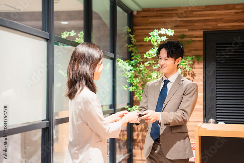 Tableau sur toile オフィスのエントランスで名刺交換をするビジネスパーソン