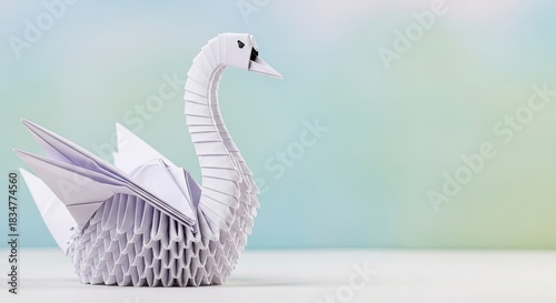 Fototapeta Naklejka Na Ścianę i Meble -  A white origami swan on a blue and green background.