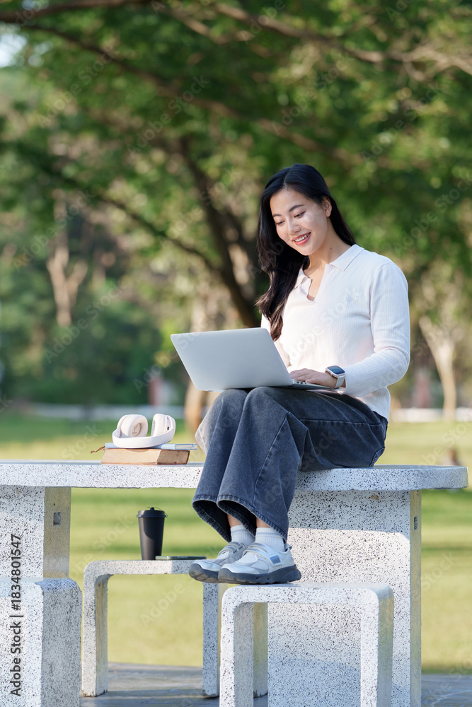 Obraz premium Asian woman studying online using laptop outdoors