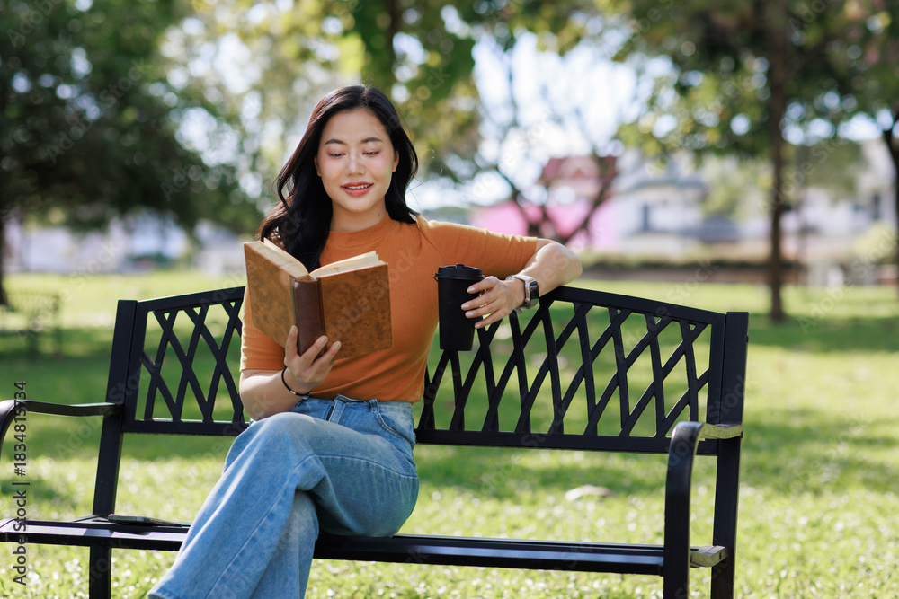 Obraz premium Young asian woman reading book in park