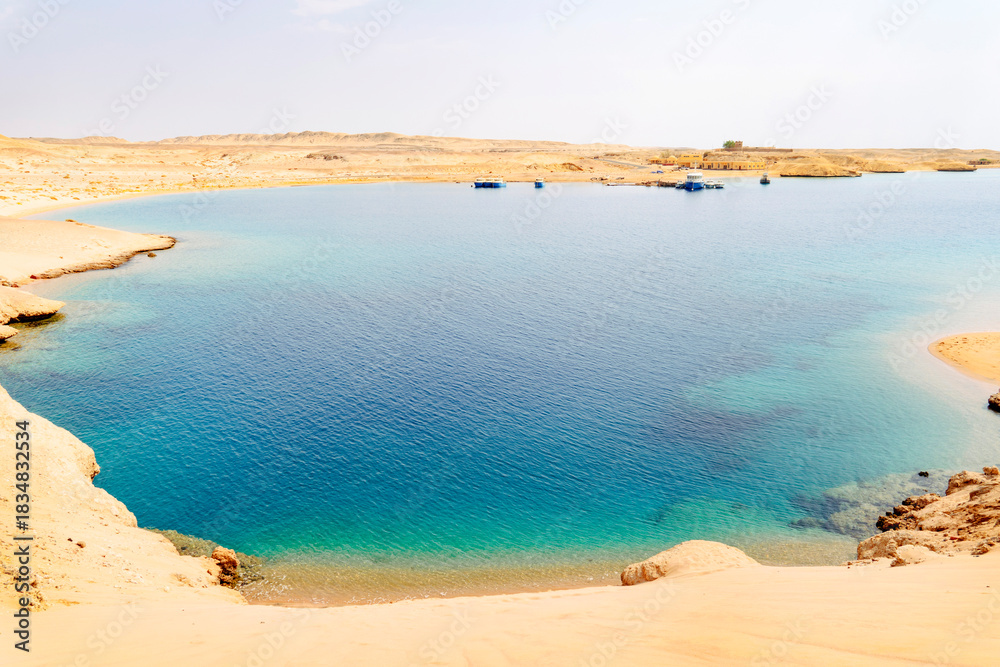 Naklejka premium a stone sandy coast in the desert. the seashore in Sharm el sheikh egypt. Bay with blue water in Ras Muhammad National Park
