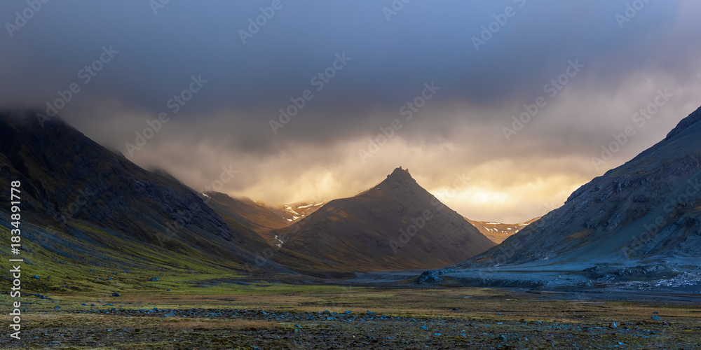 Fototapeta premium Panoramic view of Icelandic mountains with dramatic cloud cover during sunset at east coast of Iceland.