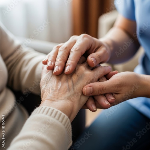 Close-up of a nurse's hands gently holding the wrinkled hands of a senior patient, symbolizing compassionate home care.