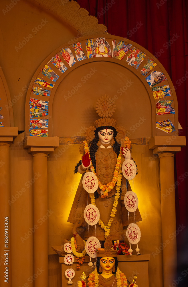 Fototapeta premium A beautifully crafted handmade colorful goddess durga idol decorated for Navratri, featuring vibrant traditional attire, intricate jewellery, and divine expressions at colorful pandal.