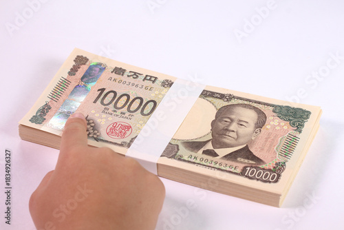 一万円札の3Dホログラムを指差す子どもの手