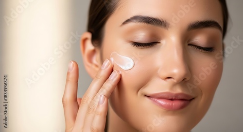 Woman applies facial cream, enjoying a moment of self-care and beauty.