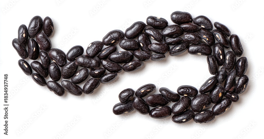 Obraz premium Close-up of black beans arranged in a curved, flowing shape on a white surface