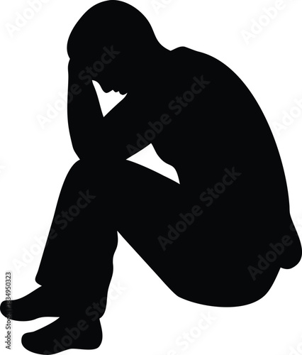 A solitary silhouette of a person sitting with their head in hands