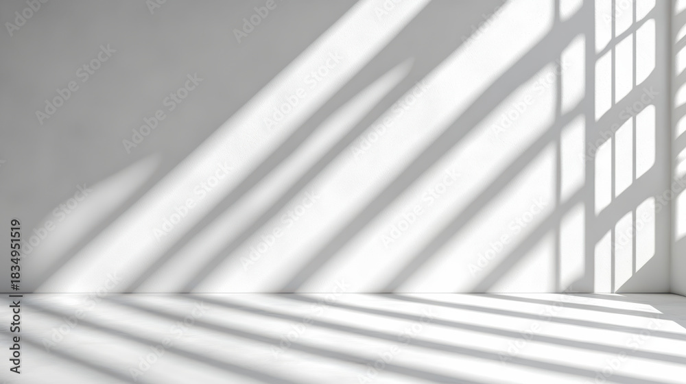 Obraz premium Soft window light casting long angled shadows across empty white floor and wall