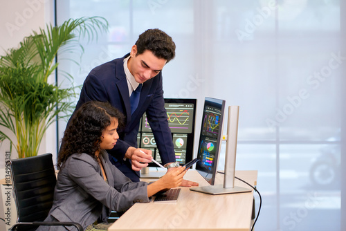 Businessman teach businesswoman to checking data with paper and computer for analyzt business trend in office.