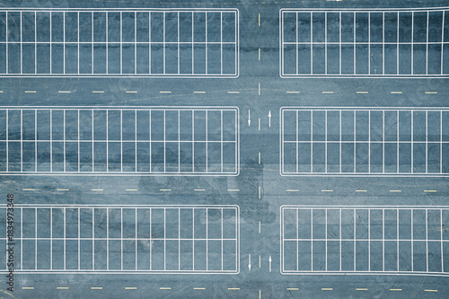Top down aerial view of empty asphalt parking lot with white lines background.