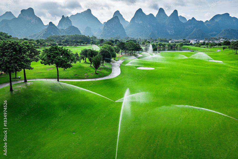 Fototapeta premium Automatic irrigation system watering the green grass on golf course field.