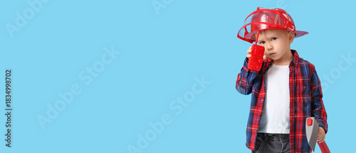 Canvas Print Cute little fireman with walkie-talkie and fireaxe on blue background