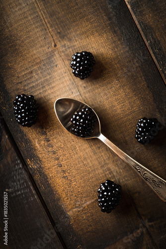 Background with black ripe blackberries on the dark background. Shot from above.