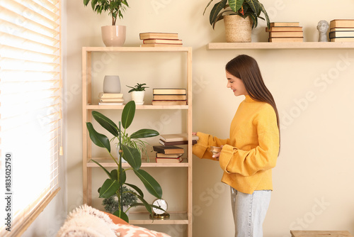Young woman putting books o...