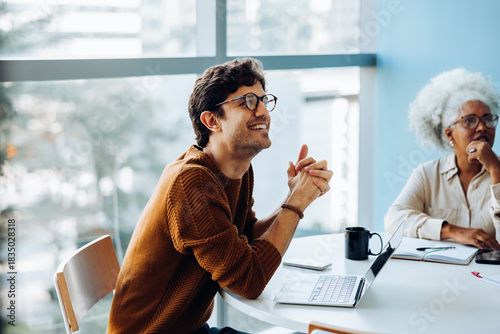 Smiling man and colleague discuss ideas in meeting