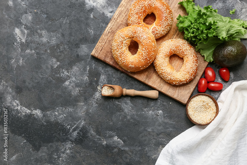 Sesame bagels on wooden boa...