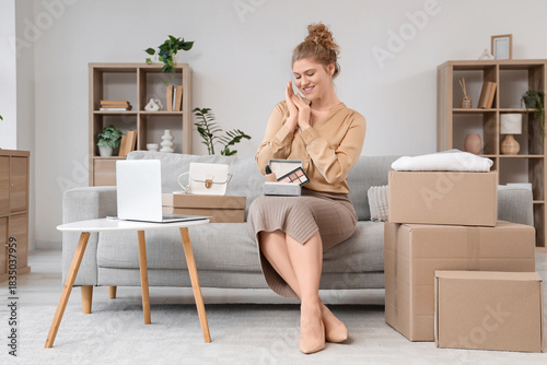 Young woman unpacking box w...