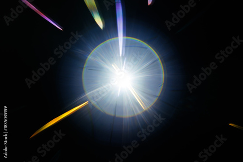 Lens Flare. Light over black background. Easy to add overlay or screen filter over photos. Abstract sun burst with digital lens flare background. Gleams rounded and hexagonal shapes, rainbow halo.