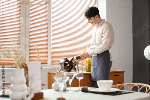 Male waiter taking bottle o...