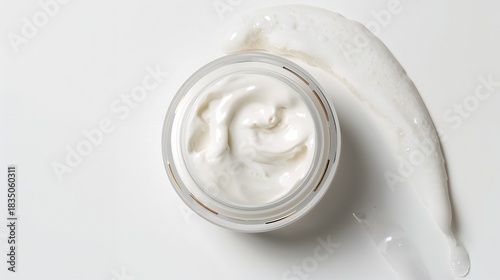 Elegant moisturizer in clear jar, a swirl of creamy goodness for skin health and beauty.