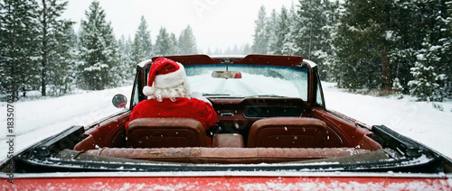 Santa Claus Driving a Classic Convertible Through a Snowy Winter Landscape for Christmas
