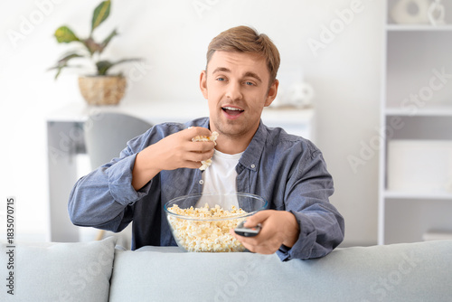 Handsome man with popcorn a...