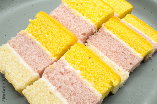 Slices of Angel Cake made up from different colours of sponge and icing.