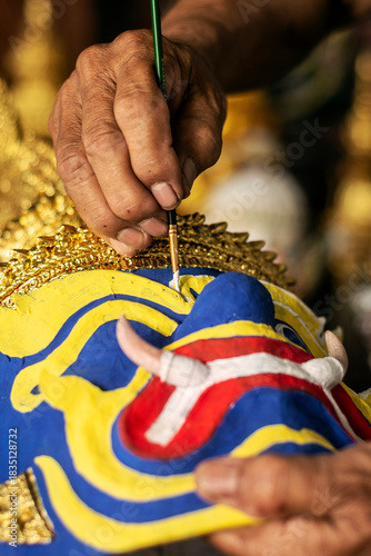close up of artist painting lakhon khol traditional mask in cambodia