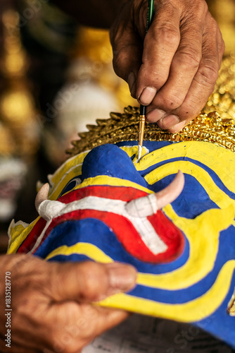 close up of artist painting lakhon khol traditional mask in cambodia